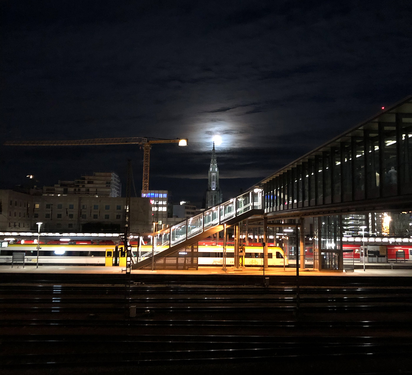 Das Ulmer Münster hinter dem Hauptbahnhof bei Vollmond